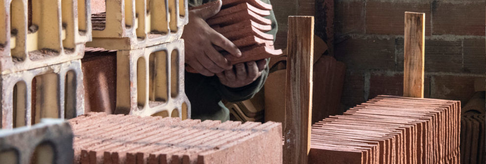 Traditional handcrafted clay roof tiles stored on pallets for delivery